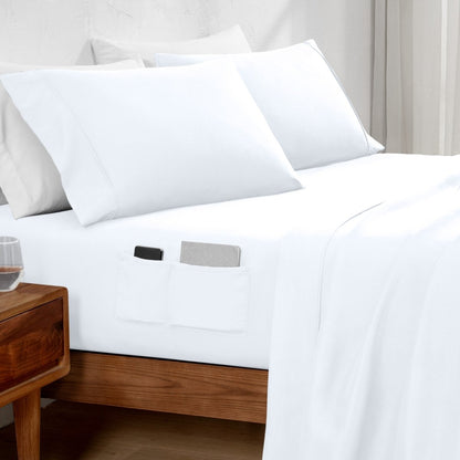 White bed sheets with pockets on a bed in a bedroom setting.