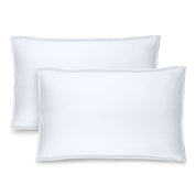 Two white pillow shams on pillows standing up with one behind the other