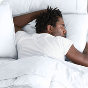 Man sleeping with his head resting on a pillow sham