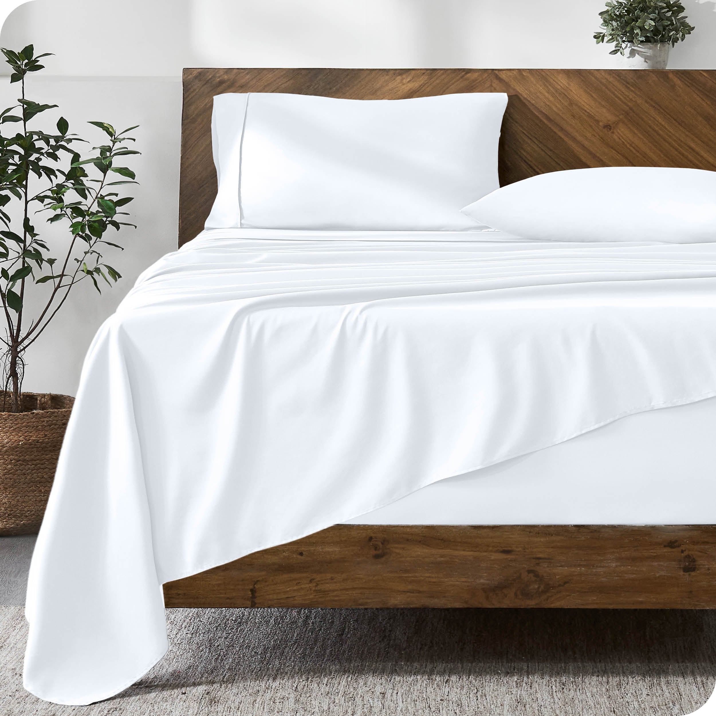 A modern bed with a microfiber sheet set on the mattress.