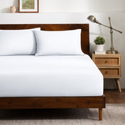 A bed dressed in a fitted sheet and two matching pillowcases.