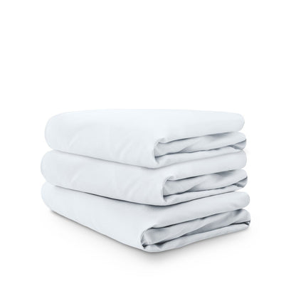 Stack of white folded crib sheets on a white background