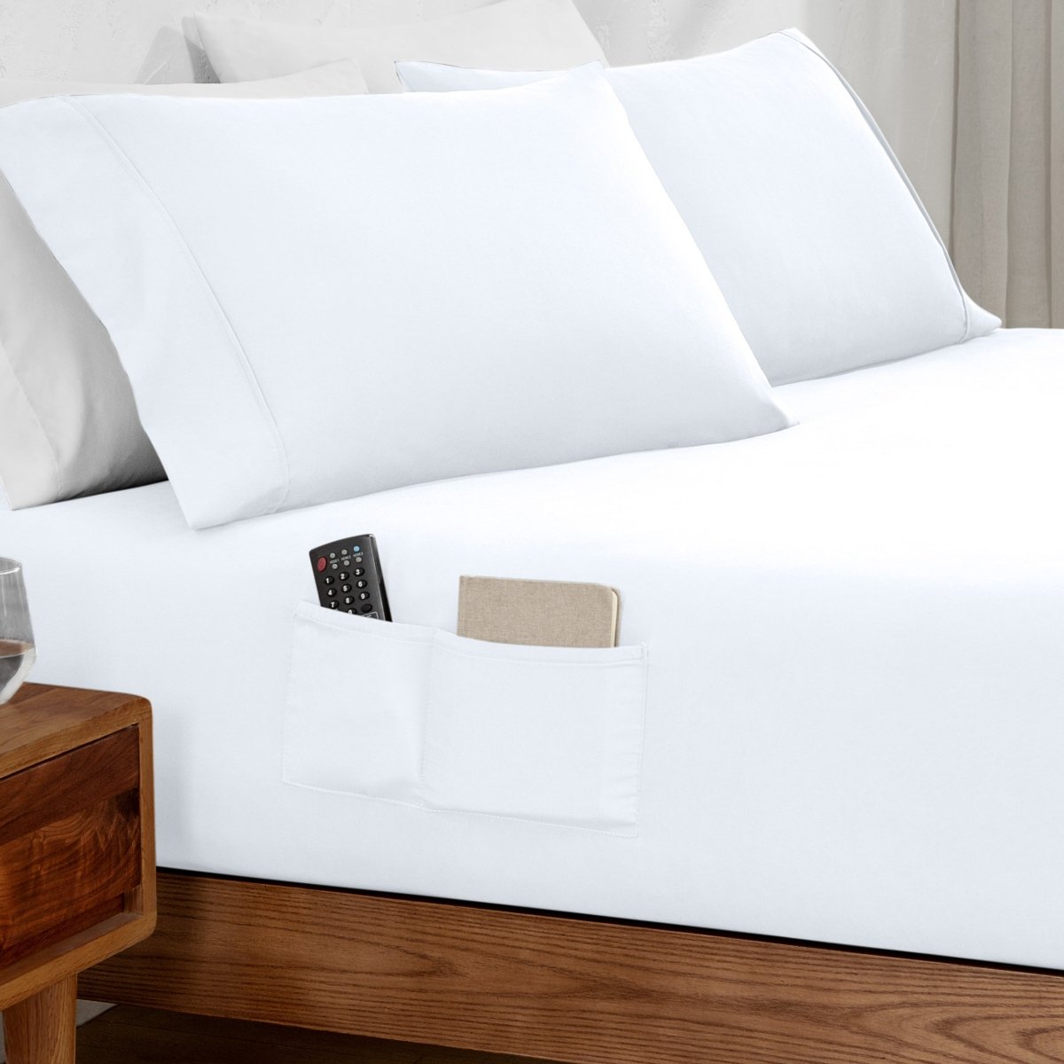 Remote control and journal in the pockets of a fitted sheet