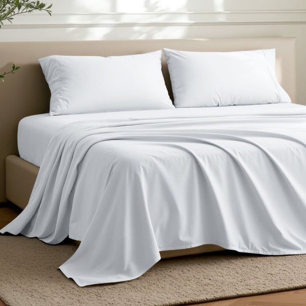 Microfiber flat sheet on a bed in a bedroom with a plant.