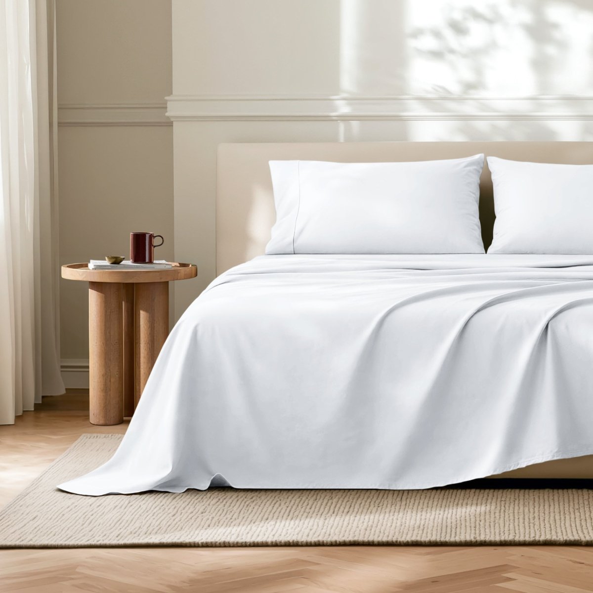 Microfiber flat sheet on a bed in a bedroom with a wooden side table.