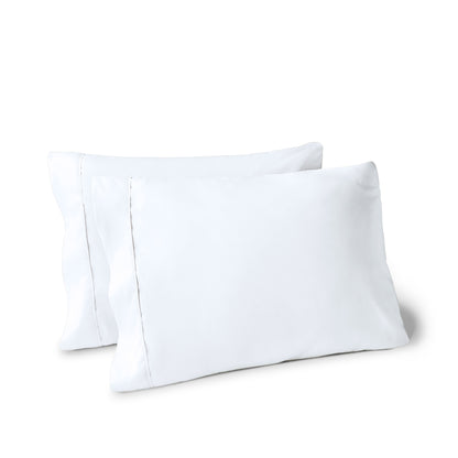 Two pillows on a white background with pillowcases on them