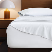 Microfiber bed sheets on a neatly made bed with a wooden headboard and nightstand.