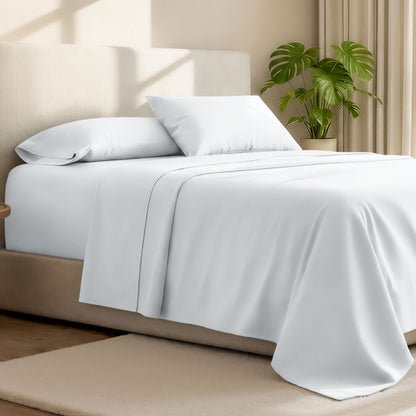 Microfiber bed sheets on a neatly made bed with a wooden headboard and nightstand.
