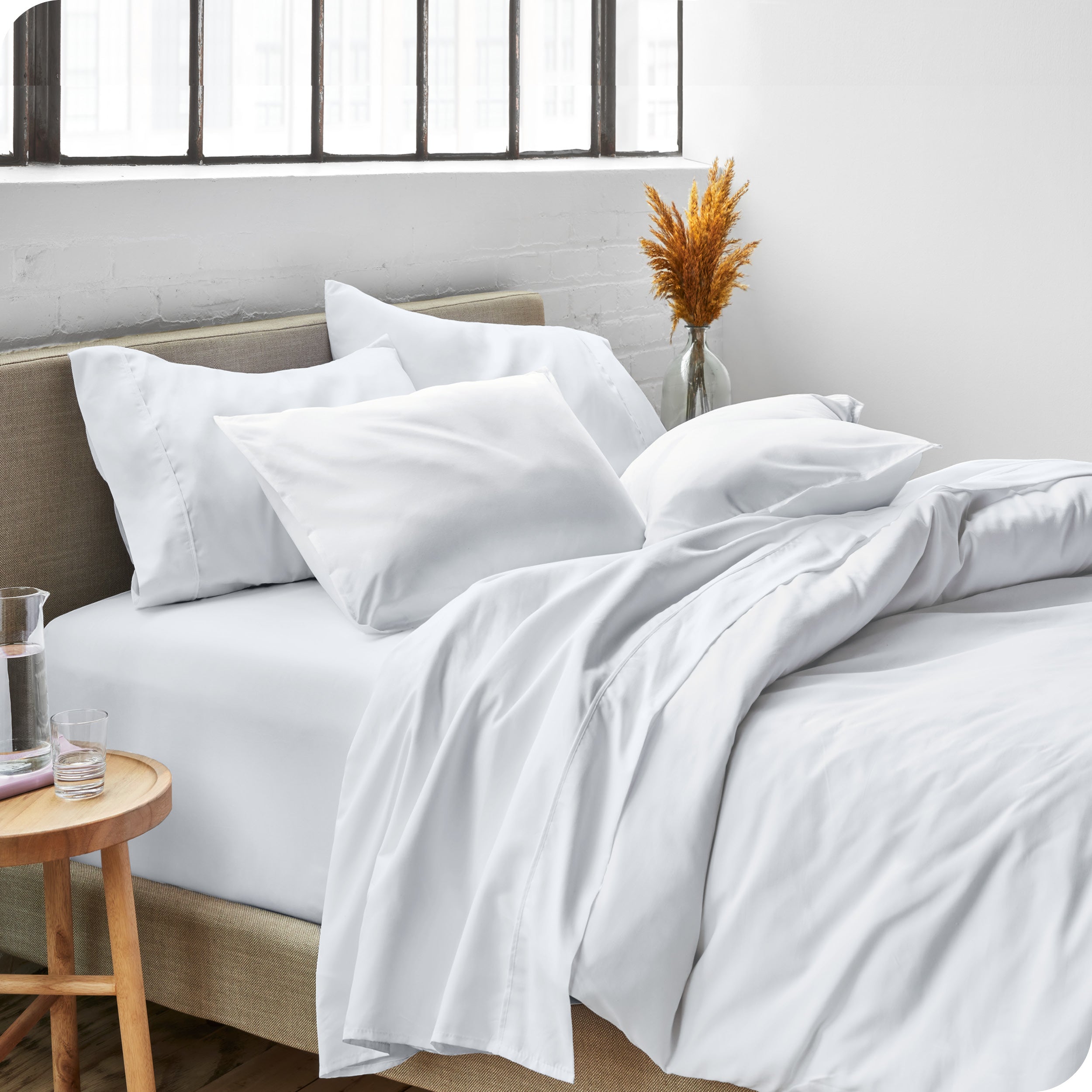 Sheets and a duvet cover on a bed in a bright bedroom