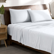 Microfiber stretch bed sheets and pillows on a wooden bed in a bedroom setting.