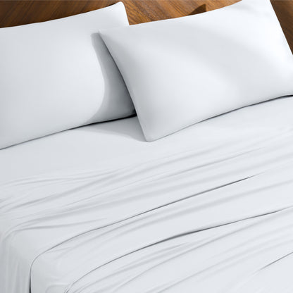 Bed sheets and pillowcases on a bed with a wooden headboard
