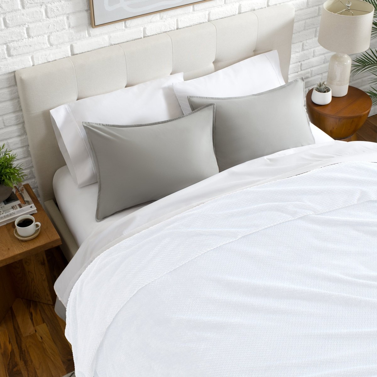 Neatly made bed with a chevron blanket over the comforter