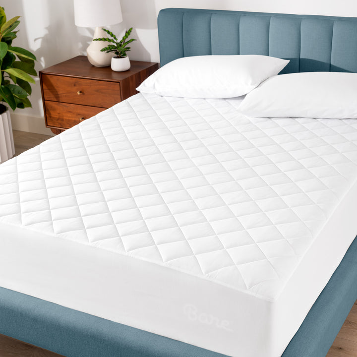 A blue bed frame with a white mattress pad on the mattress