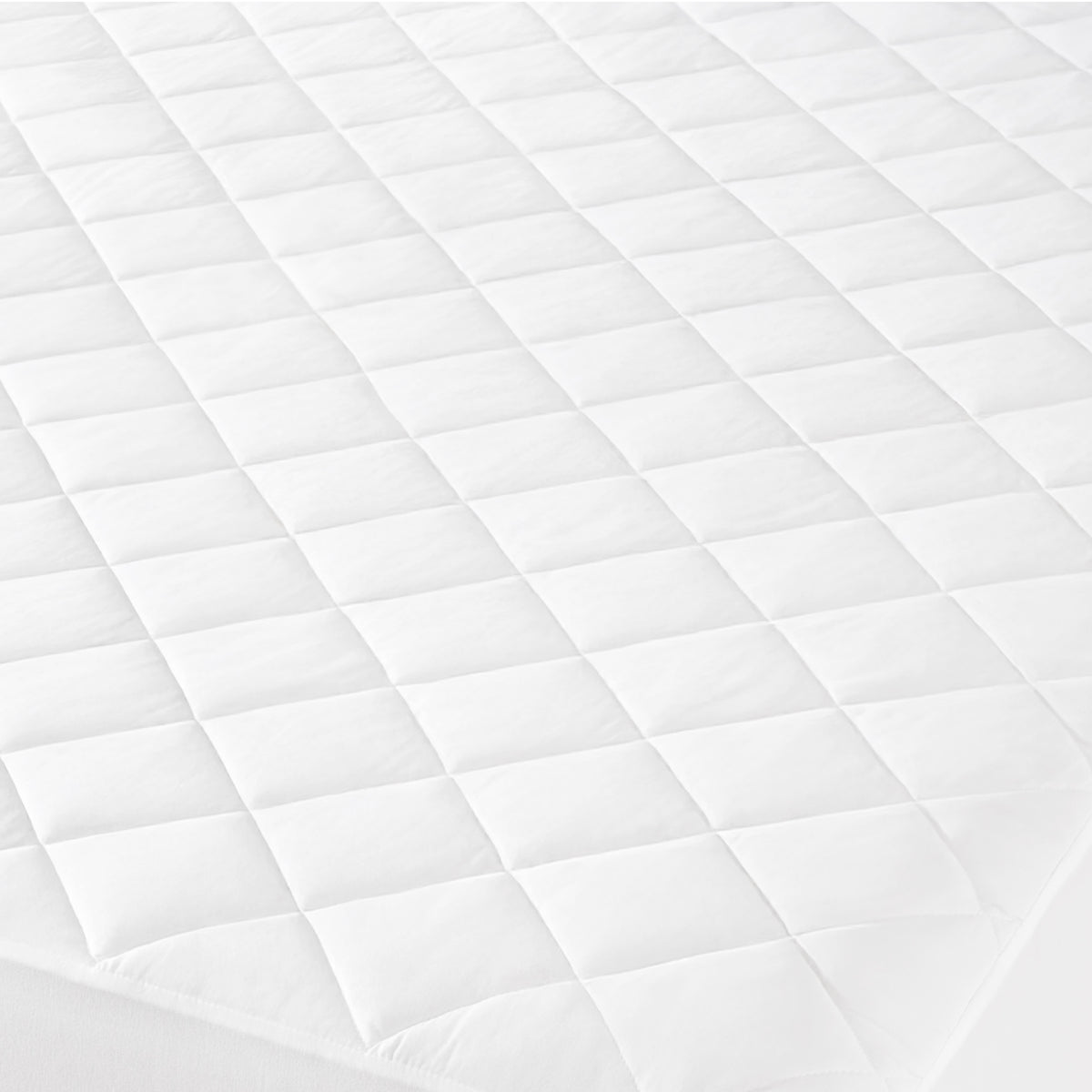 Close-up of a quilted mattress cover with a diamond pattern.