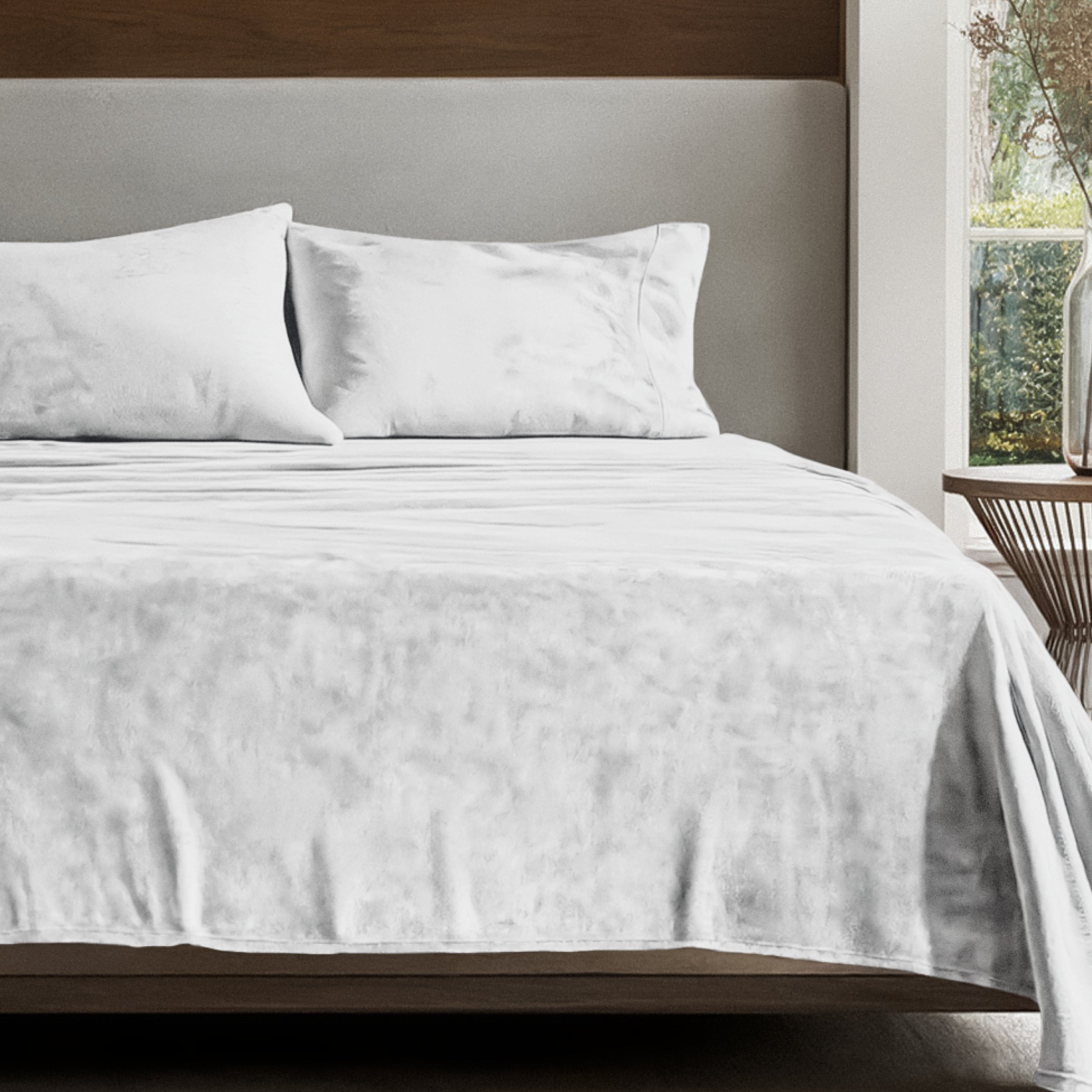 Microplush sheet set on a bed in a bedroom setting with a nightstand and lamp.