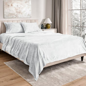 Neatly made bed in a well-lit bedroom.