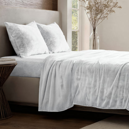 Neatly made bed in a well-lit bedroom.
