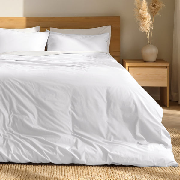 Percale bedding set on a bed with a wooden headboard and nightstand in a bedroom setting.