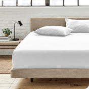 Bedroom scene with organic cotton fitted sheet and pillowcases on a bed