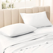Sateen bedding set on a bed with a beige headboard.