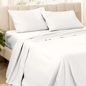 Bedding set on a bed with pillows in a bright room.
