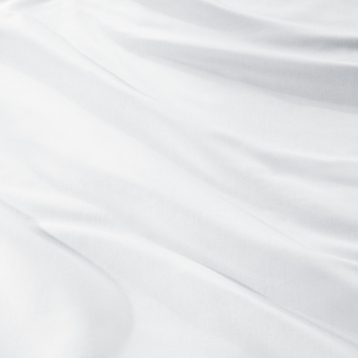 A close-up of draped sateen fabric with soft folds and a smooth texture.