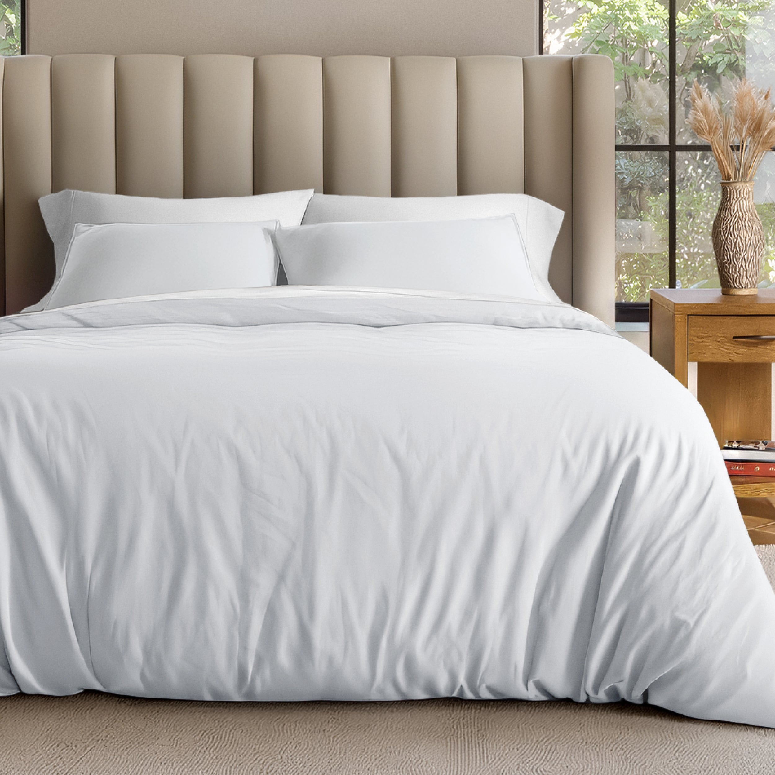 Neatly made bed with organic jersey bedding and pillow shams in a bedroom setting.