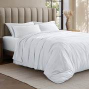 Bed with jersey duvet set against a beige headboard.