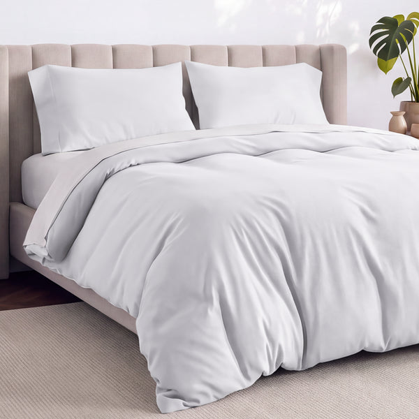 A neatly made bed with white bedding, white pillows, and a wooden headboard. 