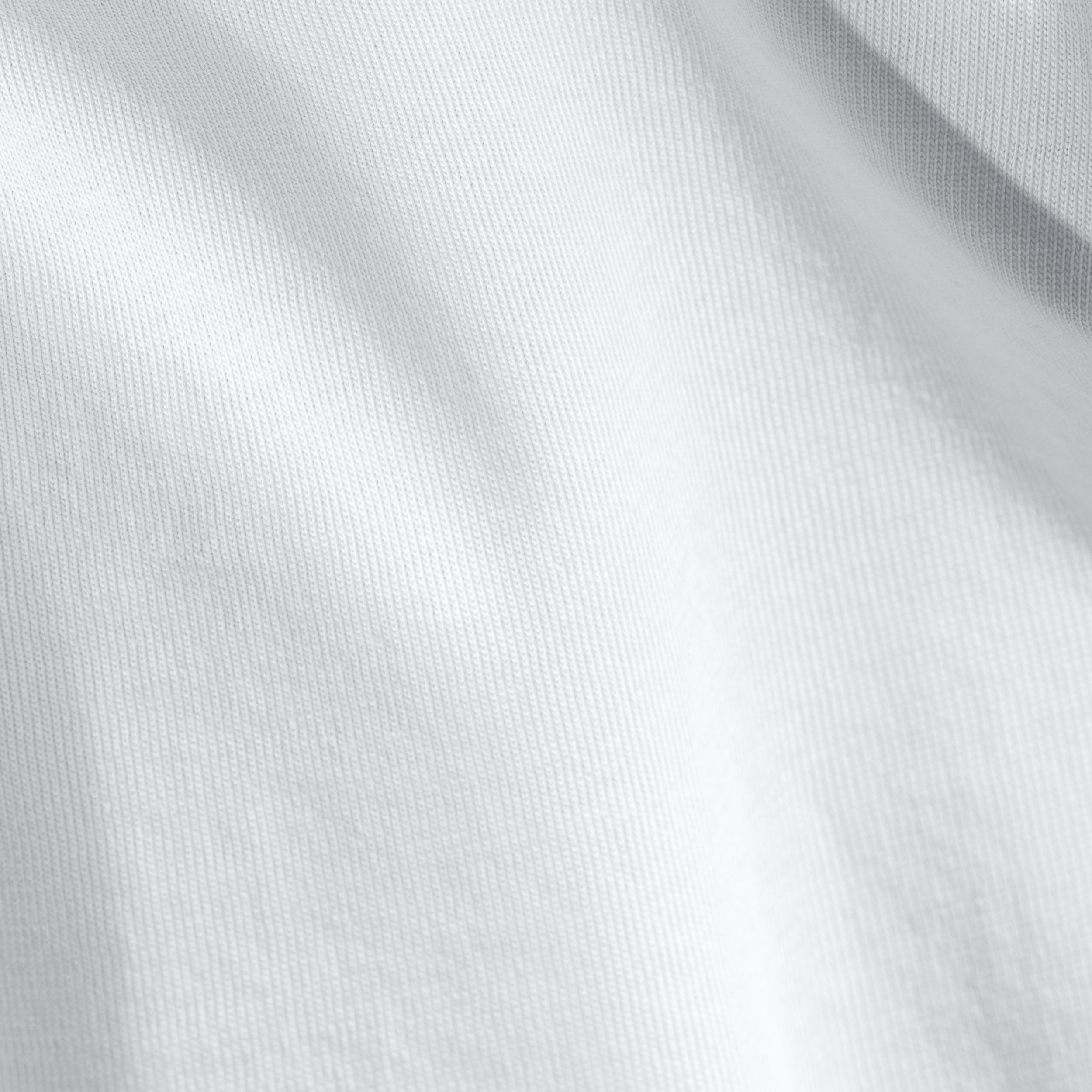 A bed with white pillows and sheets on a wooden headboard.