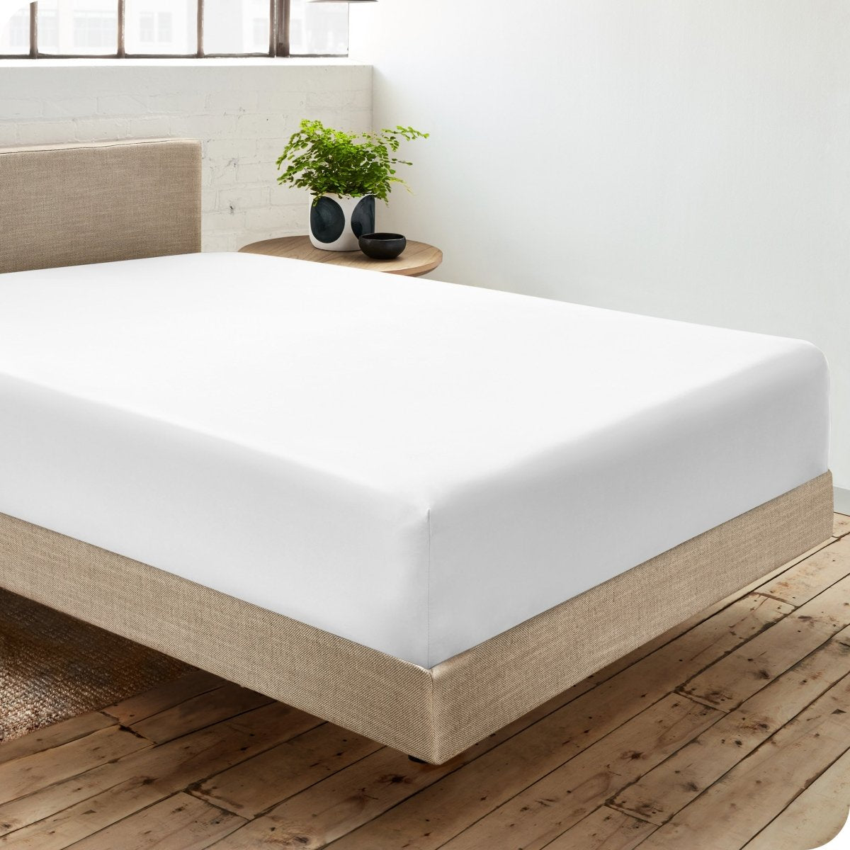 Diagonal view of room scene with percale fitted sheet on the bed