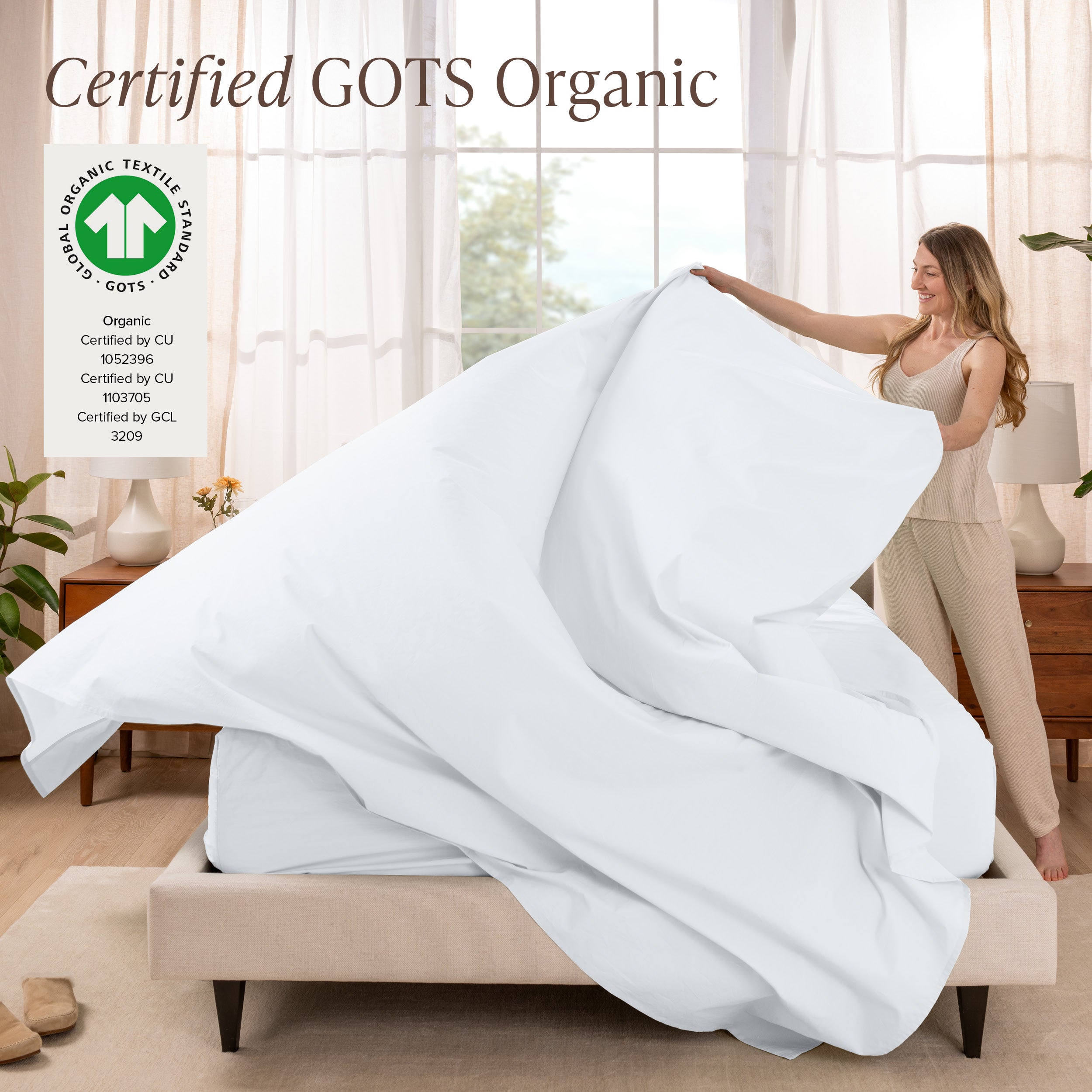 A woman is making a bed with organic cotton percale sheets