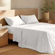 Bed with percale bedding and wooden headboard in a bedroom setting