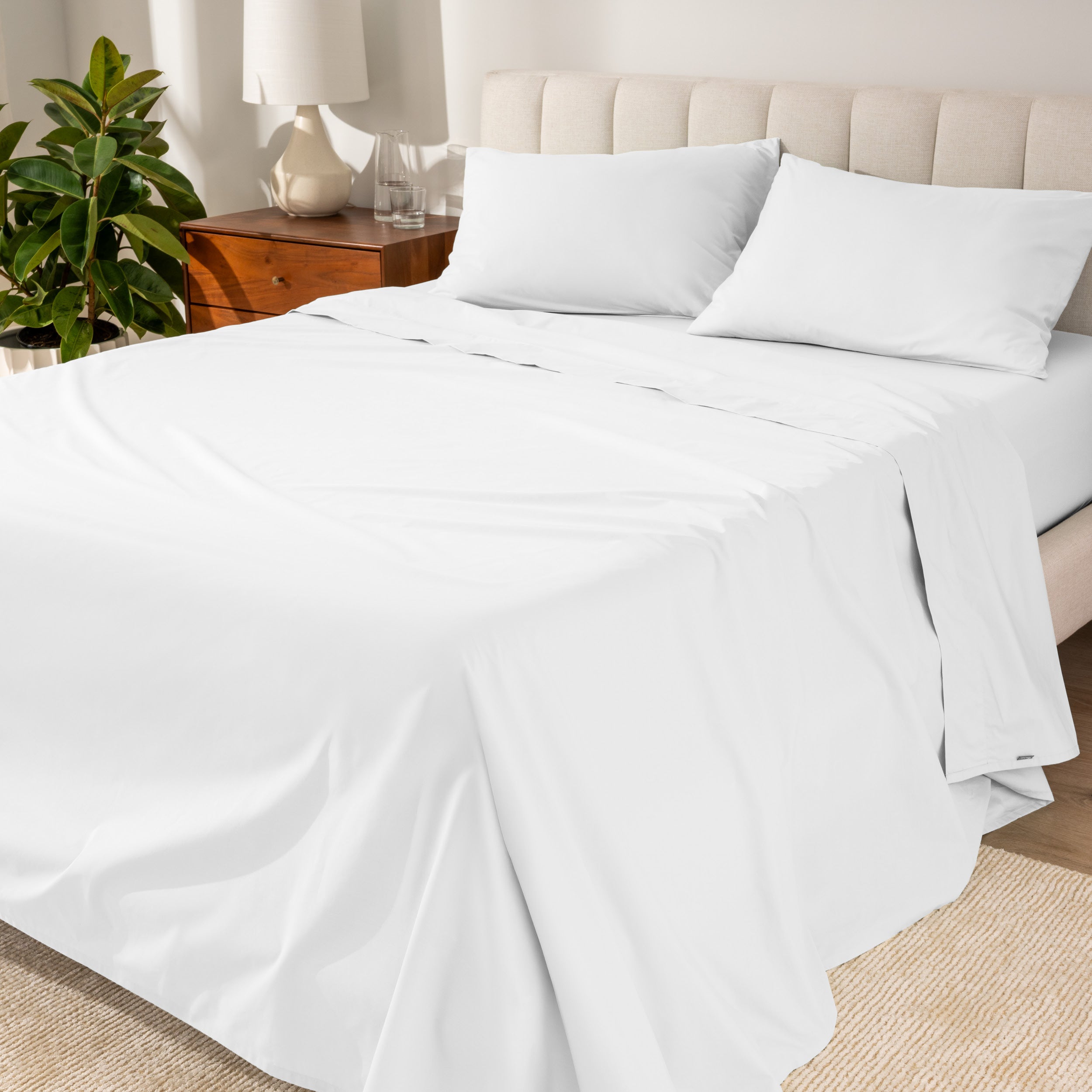 Percale sheets on a bed with a cream colored frame and headboard