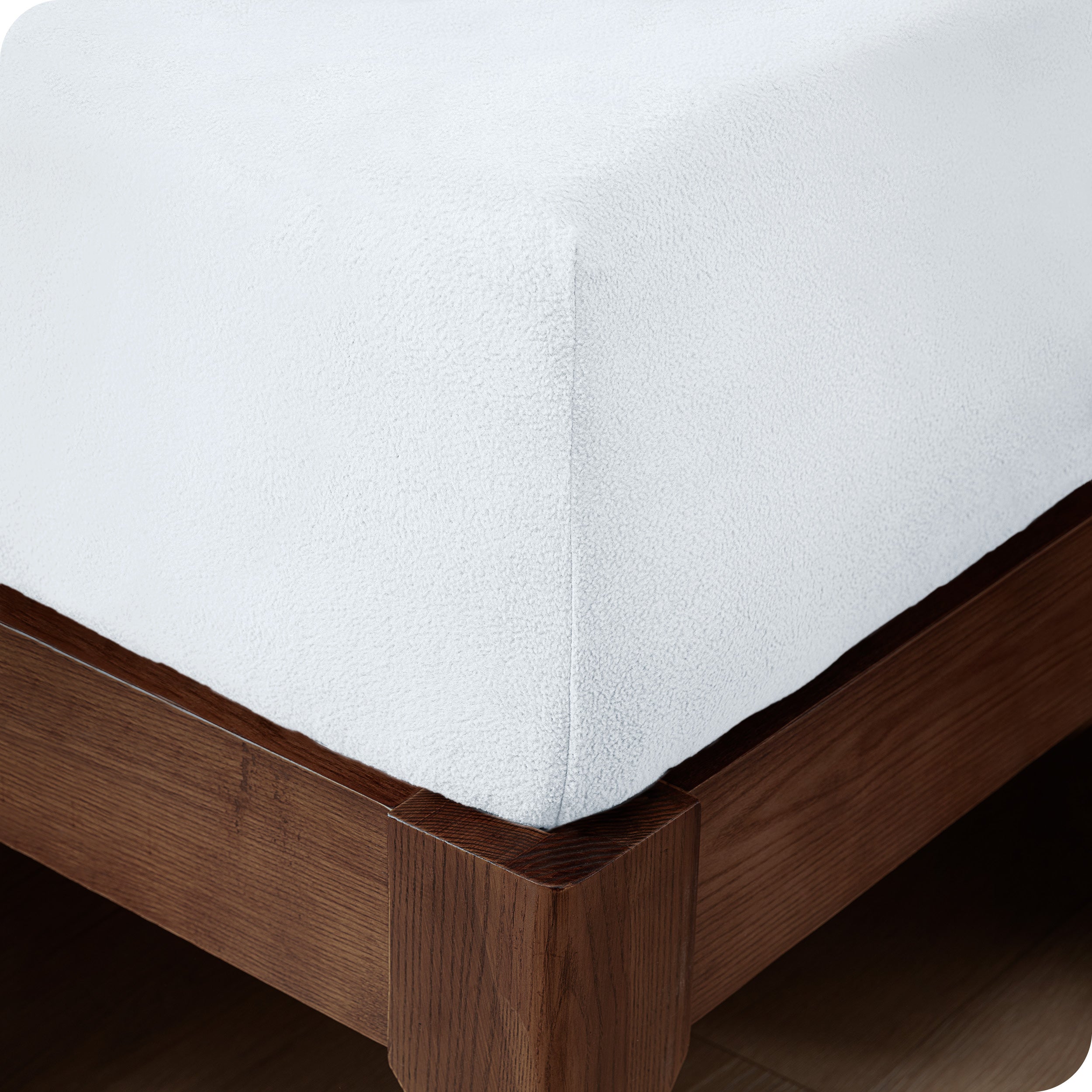 A corner of a modern bed with a polar fleece fitted sheet on.