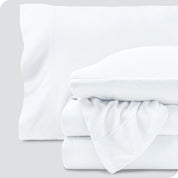 Fleece sheets folded neatly and stacked with pillows inside the pillowcases