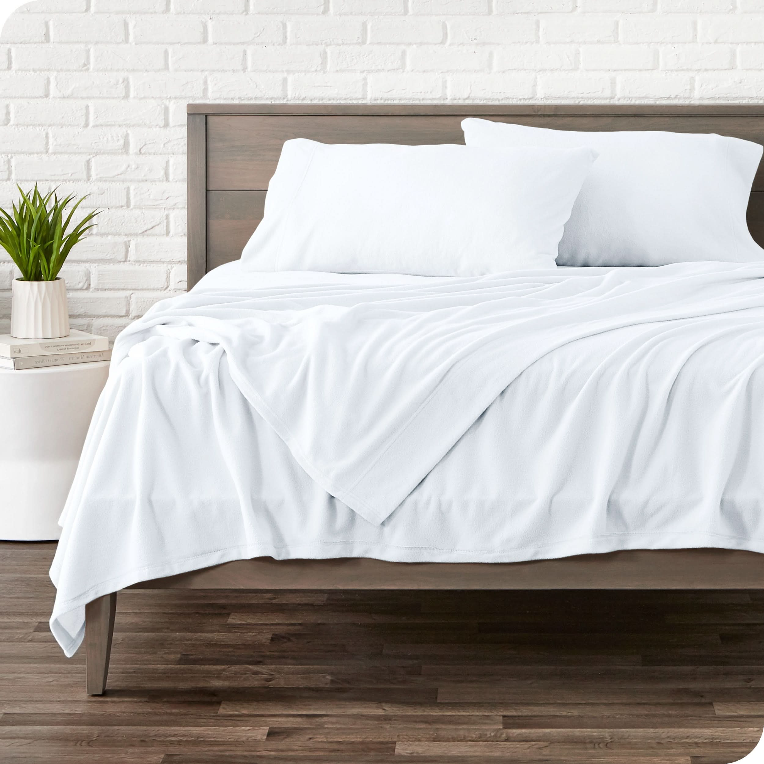 View of fleece sheets from the end of a bed with the top sheet draped over the side and end