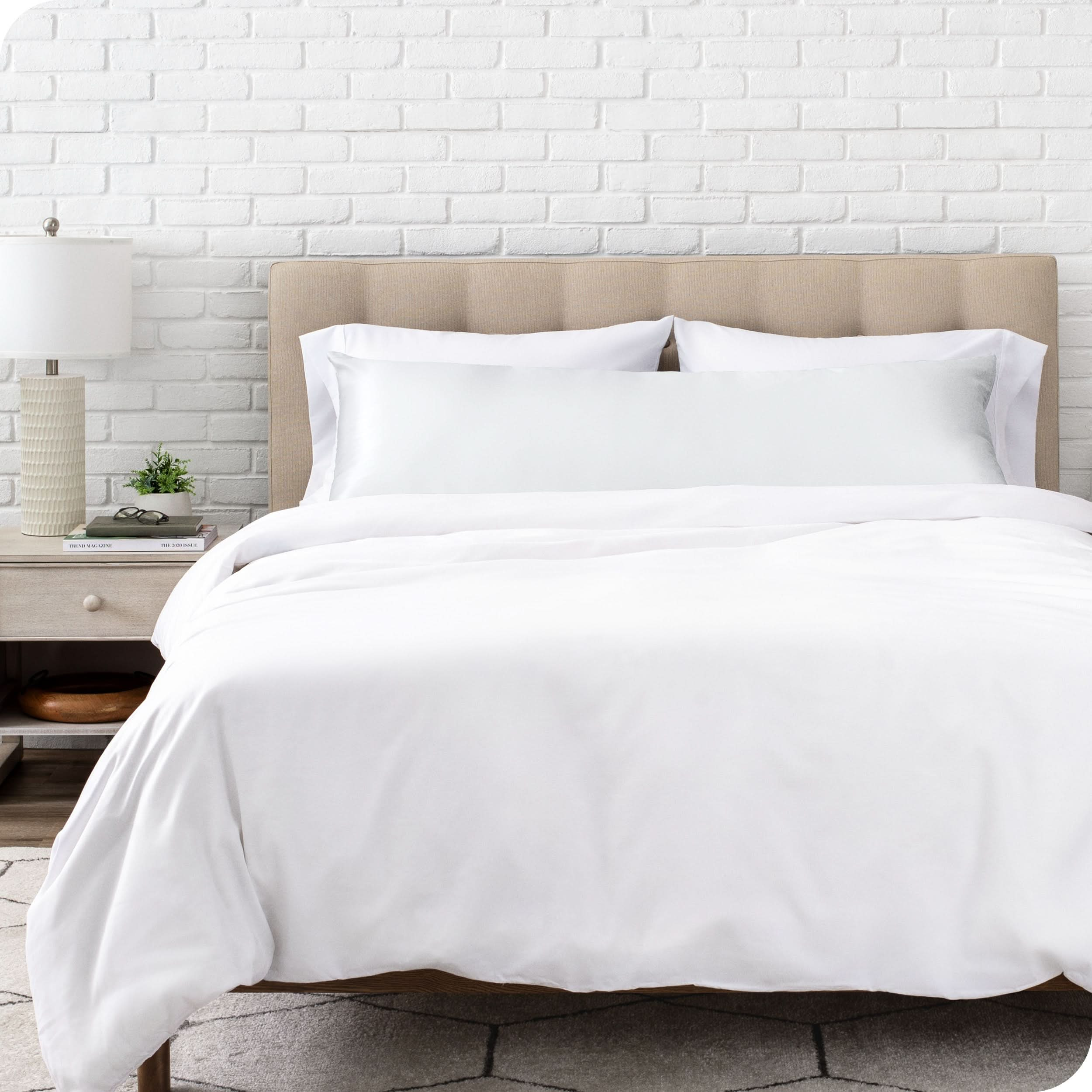 A satin body pillowcase on a bed with white linens