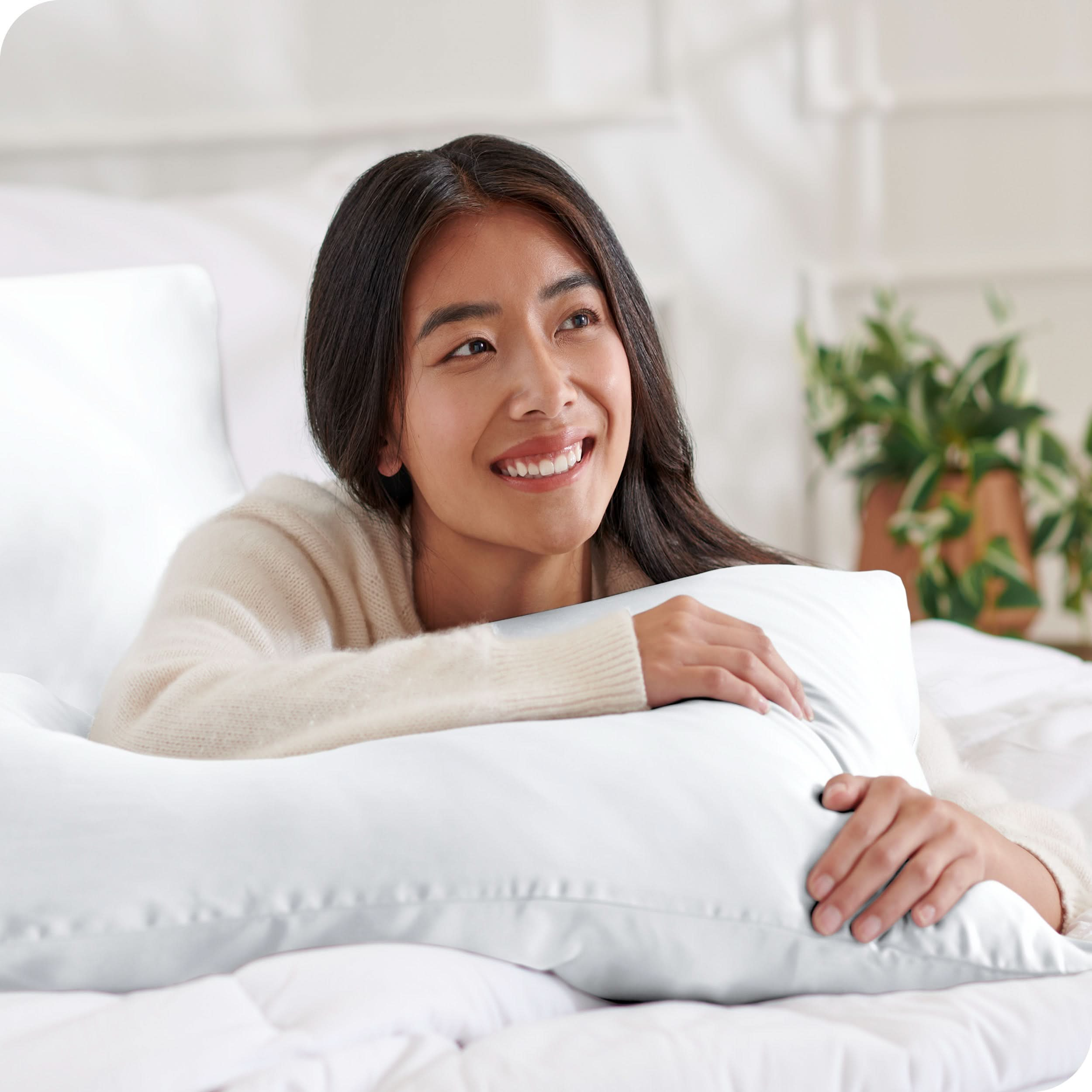 A woman is resting on a satin pillowcase covered pillow