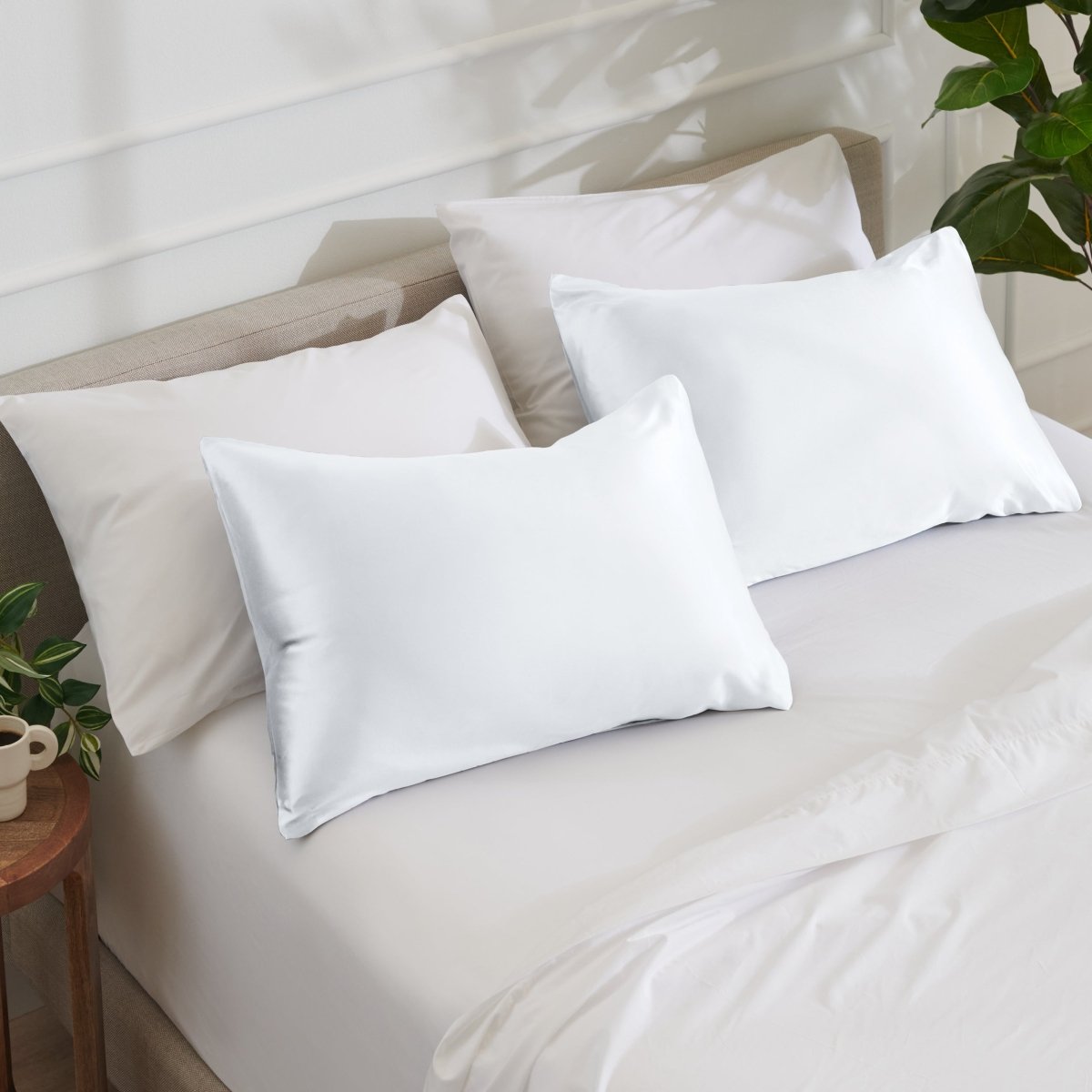 Satin pillowcases on a bed with white bedding