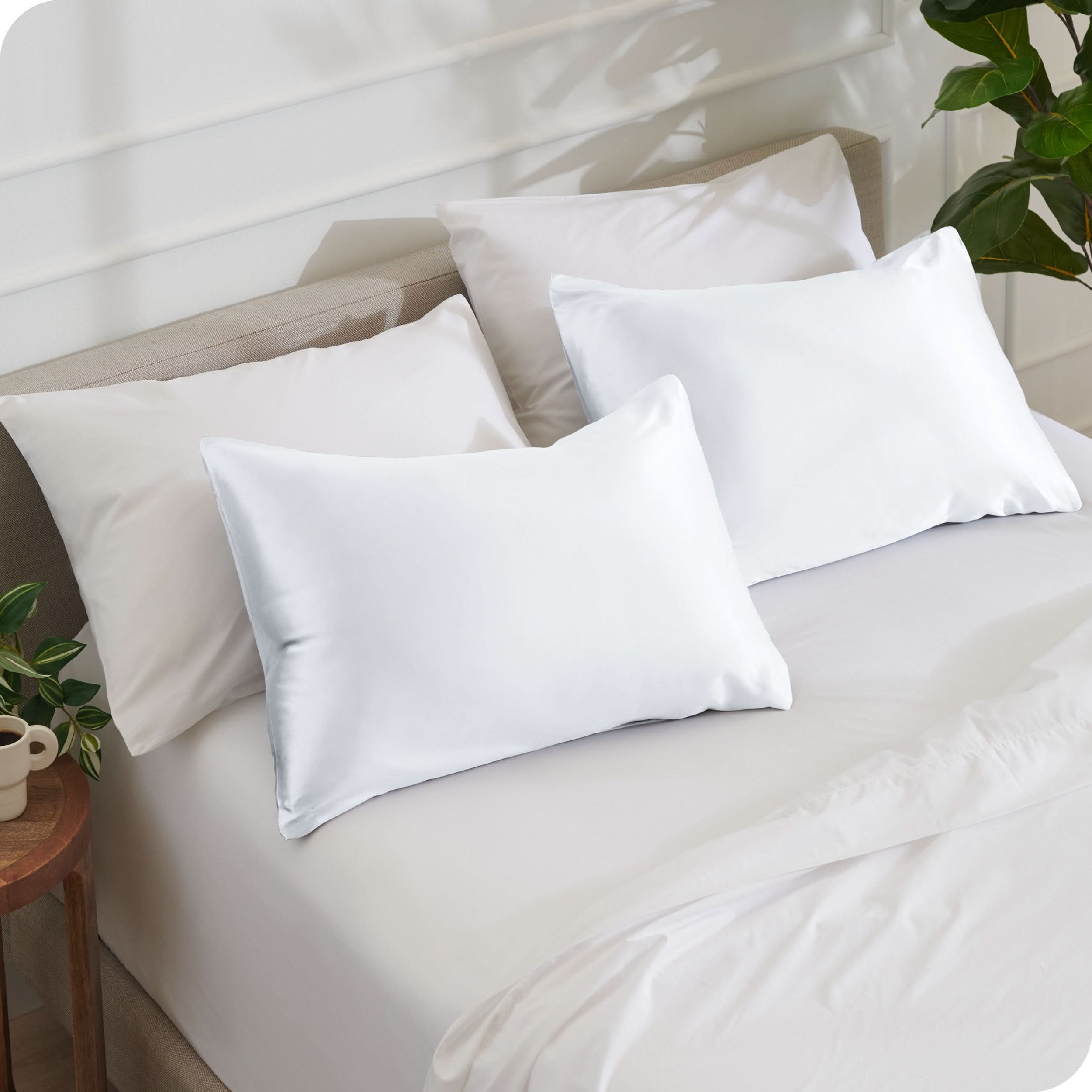 2 satin pillowcases on pillows set on a bed