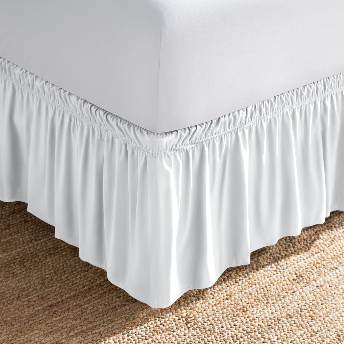 Bed with white fitted sheet and an adjustable bed skirt.