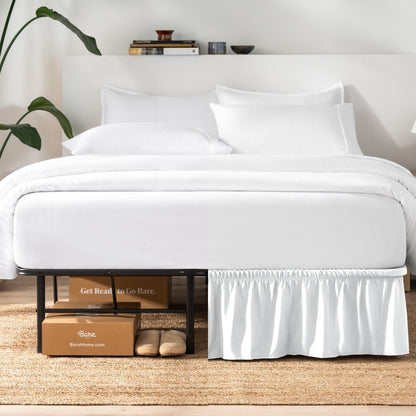 Bed with white bedding and a plant near the bed.
