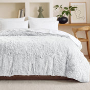 Shaggy duvet on a bed in a bedroom setting with decor elements.
