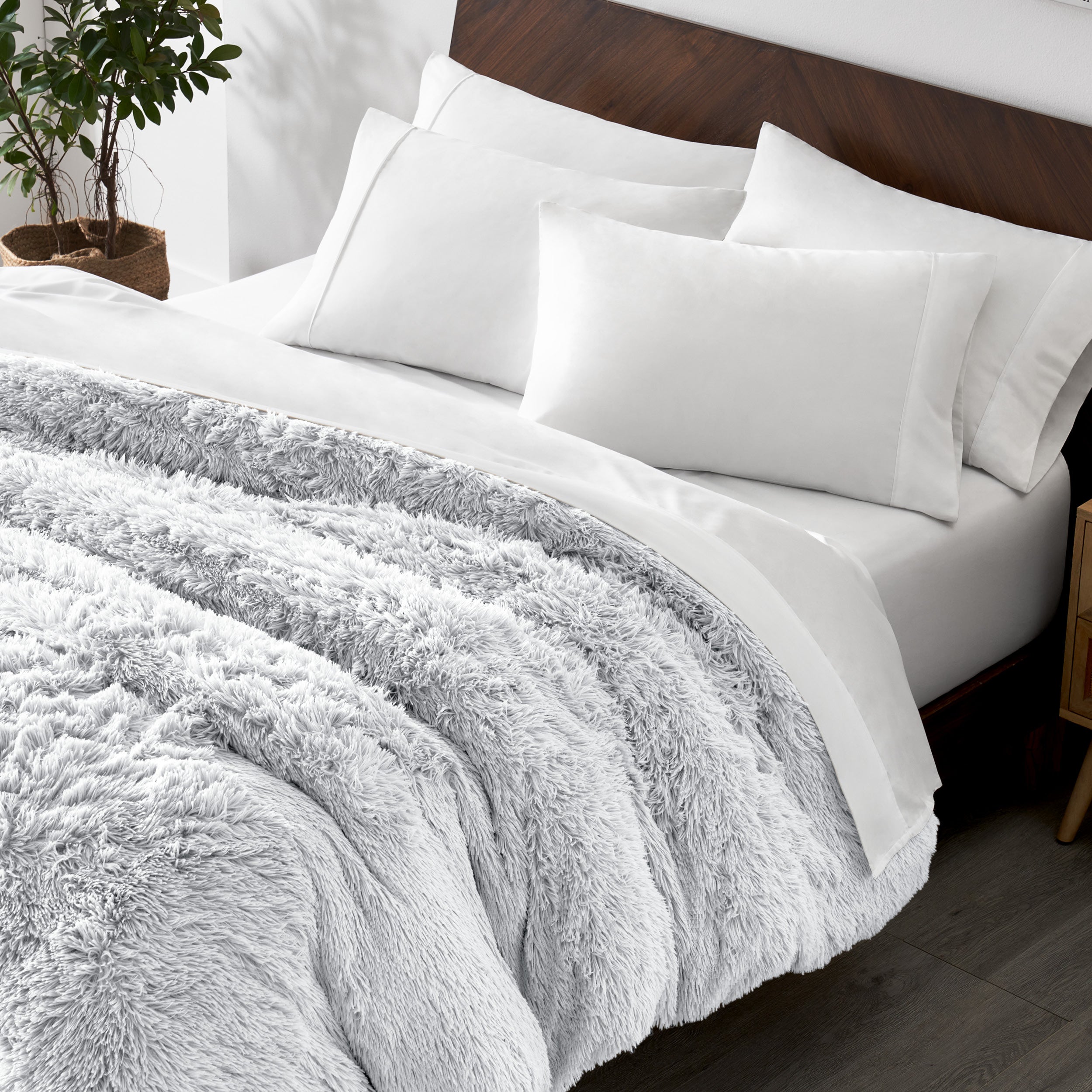 Shaggy duvet cover on a bed with white pillows and a wooden headboard.