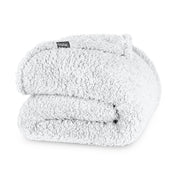 Folded textured blanket with a brand label on a white background