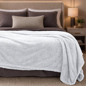 Bed with white blanket and pillows in a bedroom setting