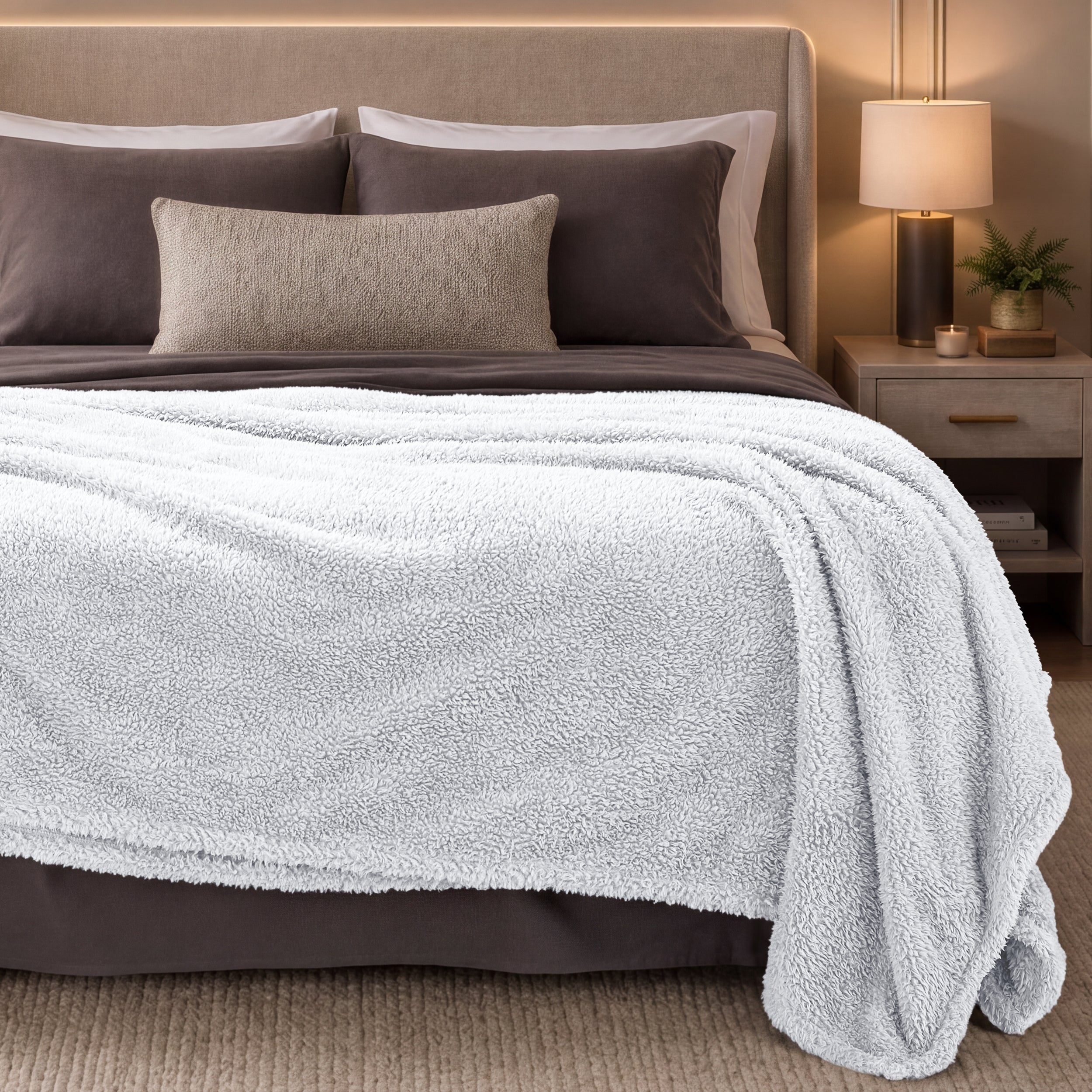 Bed with white blanket and pillows in a bedroom setting