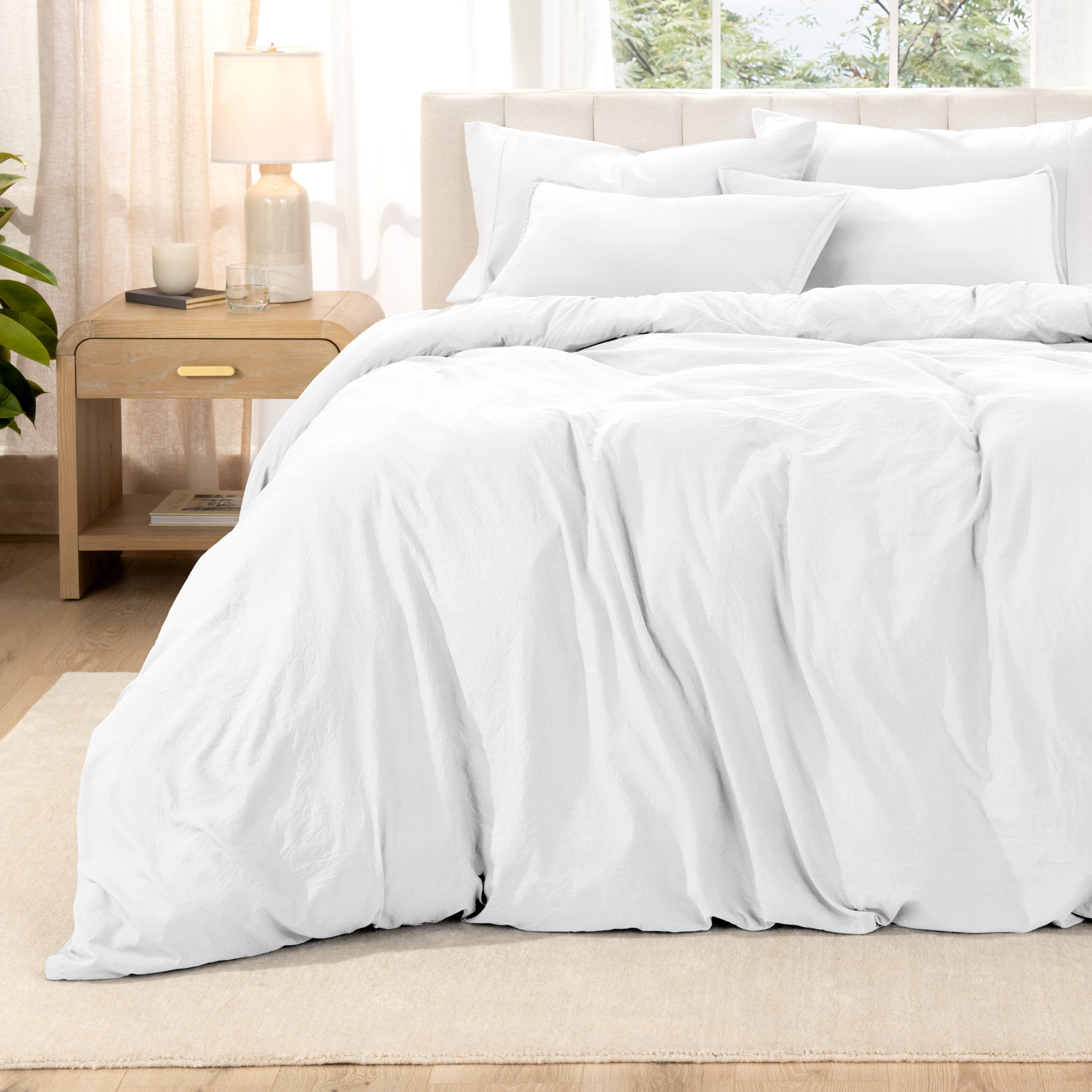 Washed bedding set on a bed with a nightstand in the background