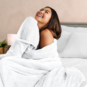 A woman smiling while wrapped in a sherpa blanket